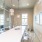 Elk Grove, CA Apartments - Vasari - Executive-Level Conference Room with Glass Dividing Wall, Long Table, Transparent Chairs, Mounted Wall Art, Pendant Lights, and Window.