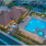 Elk Grove, CA Apartments - Vasari - Aerial View of Pool with Lounge Chairs, Tables, Umbrellas, Patio Sets, Maintained Landscaping, and Resident Lounge